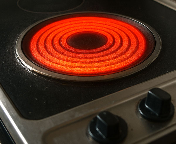 rot glühende Herdplatte warnt: Verbrenn dir nicht die Finger!