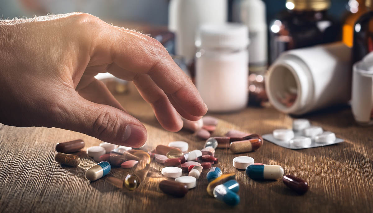 Hand greift nach Tabletten